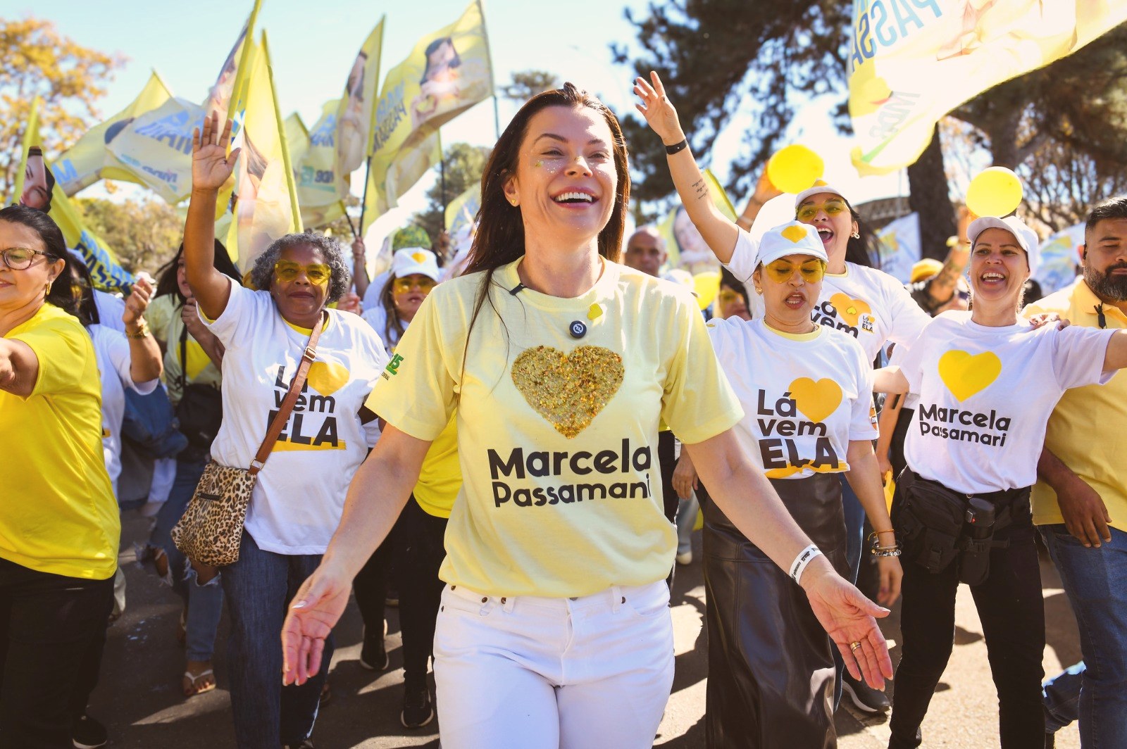 Marcela Passamani caminhando ao lado de apoiadoras
